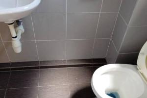 a bathroom with a white toilet and a sink at Studio House Kampar in Kampar