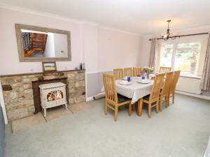 Un comedor con mesa y chimenea. en Altair, en Freshwater