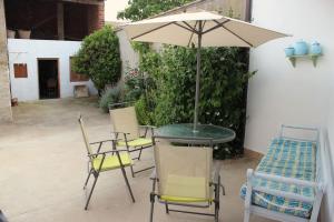 a table and chairs with an umbrella on a patio at Casa Rural Tío Samuel 