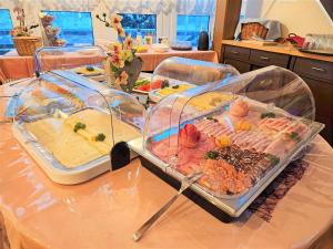 una mesa con varias bandejas de diferentes tipos de alimentos en Waldhotel Feldbachtal en Neuhaus am Rennweg