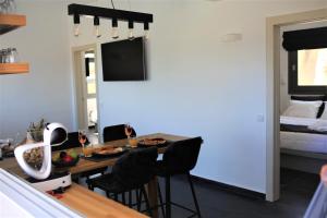 a dining room with a table and chairs and a bed at A Lux Villas Santorini in Éxo Goniá