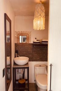 a bathroom with a sink and a toilet and a chandelier at Casa Luce in Puerto Viejo