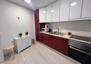 a kitchen with red and white cabinets and a sink at Casa do Gaspar in Aveiro