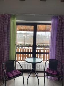 a table and two chairs in front of a window at Pogar Inn in Slavske