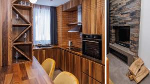 a kitchen with a table and a fireplace at Aparthotel Poljice in Jahorina