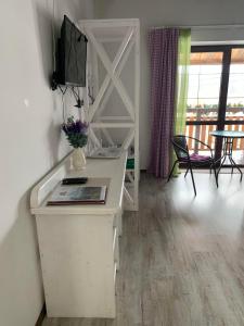 escritorio blanco con TV, mesa y sillas en Pogar Inn en Slavske