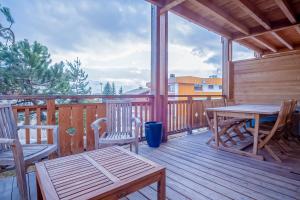 a wooden deck with a table and chairs on it at Spacious apartment with terrace - Alpe d'Huez - Welkeys in LʼHuez