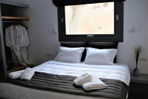 een slaapkamer met een bed met twee handdoeken erop bij A Lux Villas Santorini in Éxo Goniá