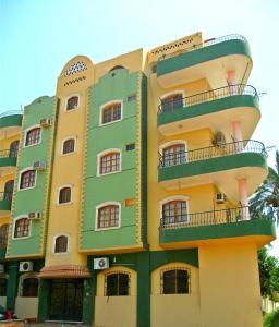 un edificio de color verde y amarillo en Farida Apartments, en Luxor