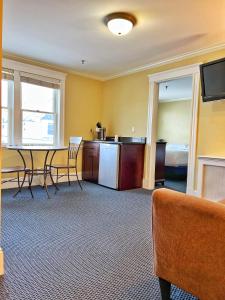 a room with a table and chairs and a kitchen at Winthrop Arms Hotel Restaurant Logan Airport in Winthrop