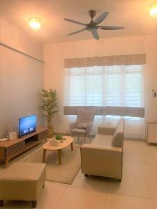 a living room with a ceiling fan and a tv at Dedaun Homestay Batu Pahat in Batu Pahat