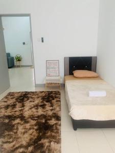a bedroom with a bed and a rug at Dedaun Homestay Batu Pahat in Batu Pahat