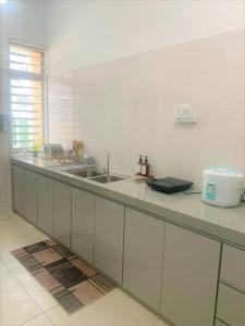 a kitchen with a sink and a counter top at Dedaun Homestay Batu Pahat in Batu Pahat