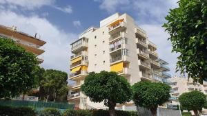 a tall white building with trees in front of it at Jescamar 2 in Salou