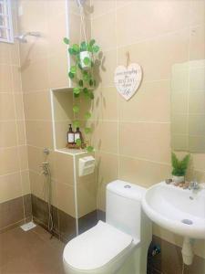 a bathroom with a toilet and a sink at Dedaun Homestay Batu Pahat in Batu Pahat