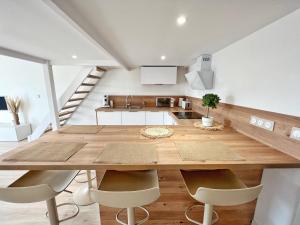 eine Küche und ein Esszimmer mit einem großen Holztisch und Stühlen in der Unterkunft Le Petit Bohème - Cocon Rochelais in La Rochelle