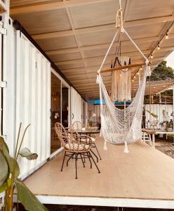 eine Hängematte auf einer Terrasse mit einem Tisch und Stühlen in der Unterkunft Casa Luce in Puerto Viejo