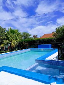 a swimming pool with blue water and palm trees at Casa MERLITO - PISCINA DE USO EXCLUSIVO - HERMOSAS VISTAS A LAS SIERRAS -VILLA DE MERLO - SAN LUIS in Merlo