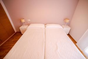 Dormitorio pequeño con 2 camas y 2 lámparas en Castellon Ribalta Apartments - Parking disponible, en Castellón de la Plana