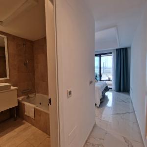ein Bad mit einem Bett und einer Badewanne in einem Zimmer in der Unterkunft Casares del Mar Luxury Apartment in Málaga