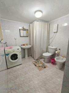 a bathroom with a washing machine and a toilet at Isaac's Home in Beit Sahour