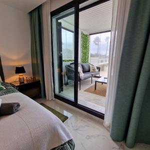 Schlafzimmer mit einem Bett und einer Glasschiebetür in der Unterkunft Casares del Mar Luxury Apartment in Málaga