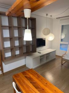 ein Wohnzimmer mit einem Tisch und einem TV in der Unterkunft BaruHaus Nido Valencia de don Juan in Valencia de Don Juan