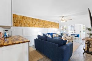 a living room with a blue couch and a table at Premier 2BD Waterfront Condo Barefoot Beach Resort in Clearwater Beach