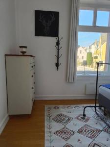 a room with a bed and a window and a rug at Cozy, Central, Ocean View in Ålesund