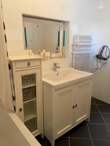 a white bathroom with a sink and a mirror at Charming Villach Hideaway - 1BR in Villach