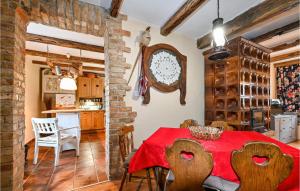 cocina y comedor con mesa roja y sillas en 2 Bedroom Cozy Home In Hrastovica, 