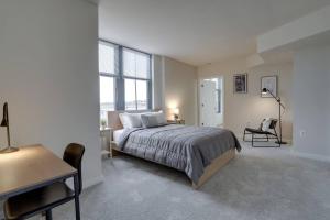 a bedroom with a bed and a table and a desk at Wonderful 2 BR Condo At Pentagon City with Gym in Arlington