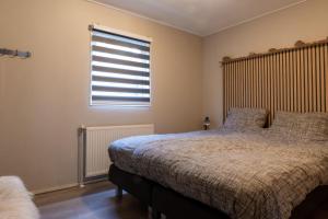 1 dormitorio con 2 camas y ventana en Drents Genieten - Dopheide met privé jacuzzi en sauna en Erm