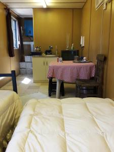 a room with a table and a table and a kitchen at Habitación con baño privado containers, auto sustentable in Pelluhue