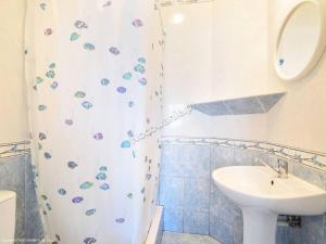 a bathroom with a sink and a shower curtain at Pokoje Mariola in Karwia +12 photos