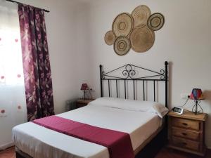 Schlafzimmer mit einem Bett und einem Wandspiegel in der Unterkunft Casa Rural Asgard in Chiclana de la Frontera