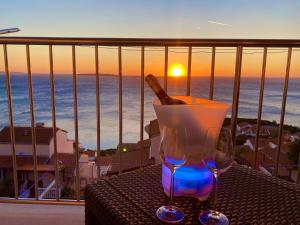 a bottle of wine and two glasses on a table with the ocean at Tanis Ocean Loft in Martinšćica
