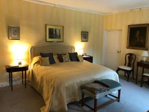 a bedroom with a bed and two chairs and two lamps at Marston Hall in Grantham