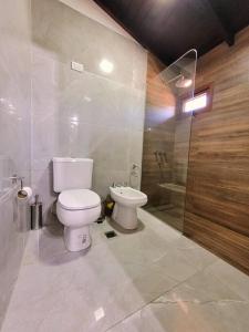 ein weißes Badezimmer mit Toilette und Dusche in der Unterkunft Casa en San Carlos de Bariloche in San Carlos de Bariloche + 9 Fotos