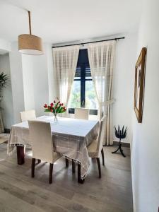 a dining room with a white table and chairs at Un tros de Sal. Casa Rural a Gerri de la Sal. in Gerri