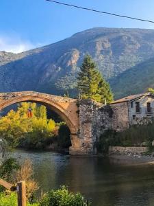 a bridge over a river with a mountain in the background at Un tros de Sal. Casa Rural a Gerri de la Sal. in Gerri