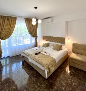 a bedroom with a large bed and a couch at Villa Perla di Mare in Kranevo