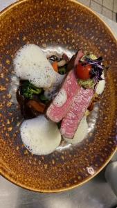 un plato de comida con carne y verduras en una mesa en Hotel Restaurant Onkel-Otto, en Pommern