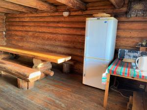 - un réfrigérateur dans une cabane en rondins avec un banc dans l'établissement Saunamaja, à Myza Kastre