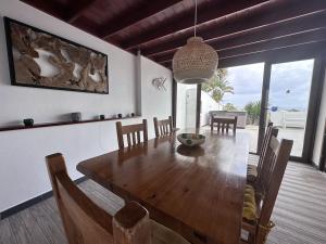 a dining room with a wooden table and chairs at Villa Bella Vista in Playa Blanca
