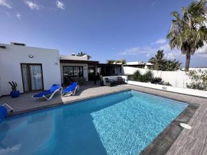 a swimming pool in front of a house at Villa Bella Vista in Playa Blanca