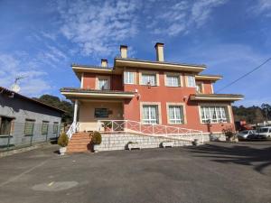 a large orange building with a driveway in front of it at Apartamentos Bricia in Posada de Llanes