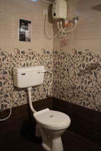 uma casa de banho com WC e papel de parede preto e branco em Zebra Hostels em Varkala