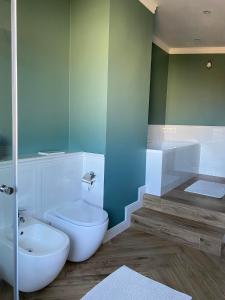 a bathroom with a white toilet and a shower at Apartament DeLux in Pasłęk