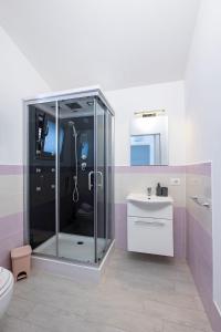 y baño con ducha acristalada y lavamanos. en Brezza Salina, en Torre Nubia